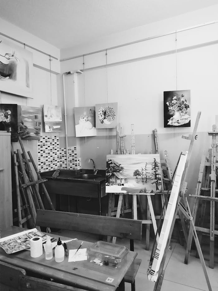 Monochrome art studio featuring paintings on easels, evoking creativity and inspiration.